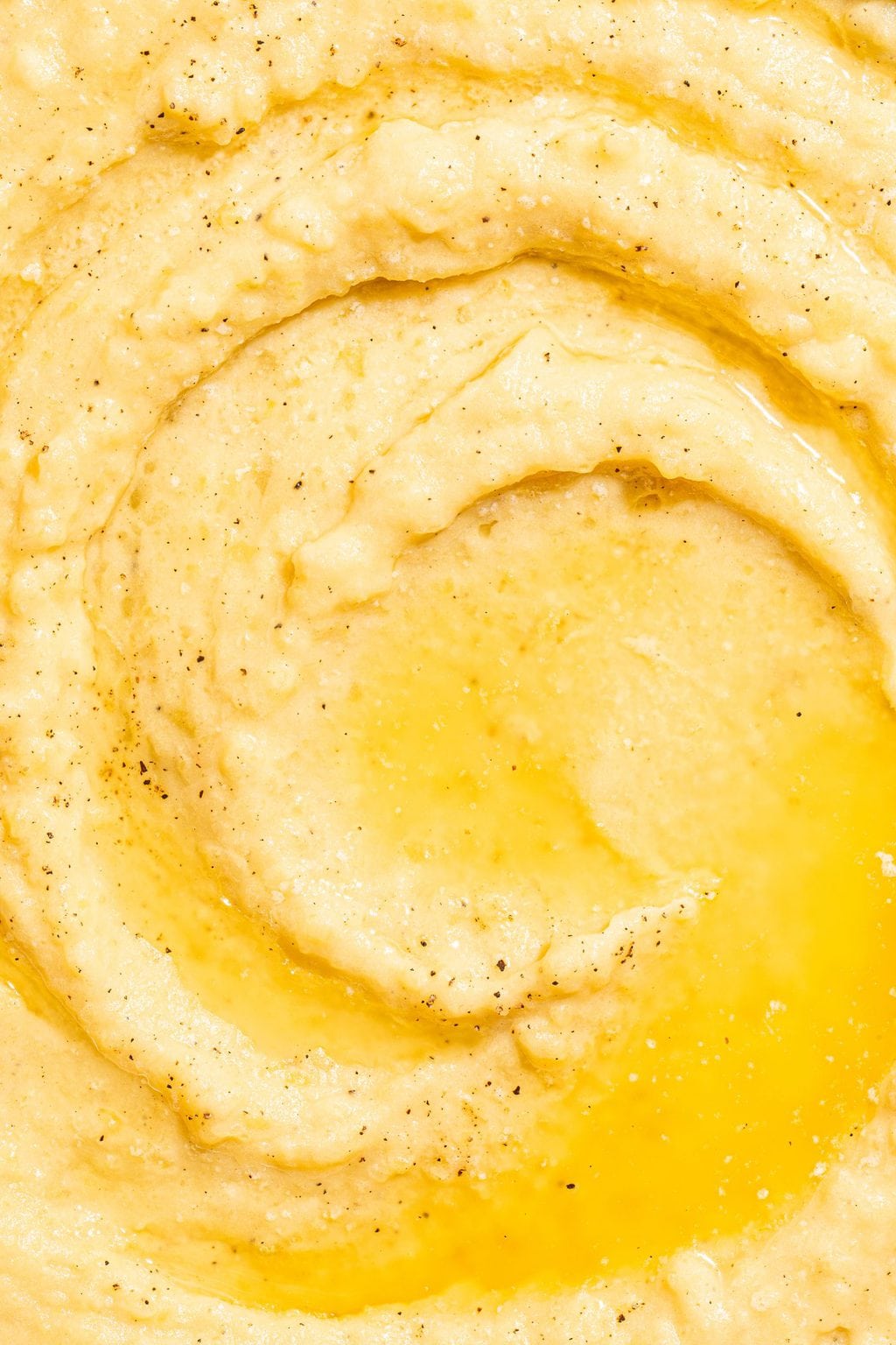 close up of creamy potatoes topped with melted butter