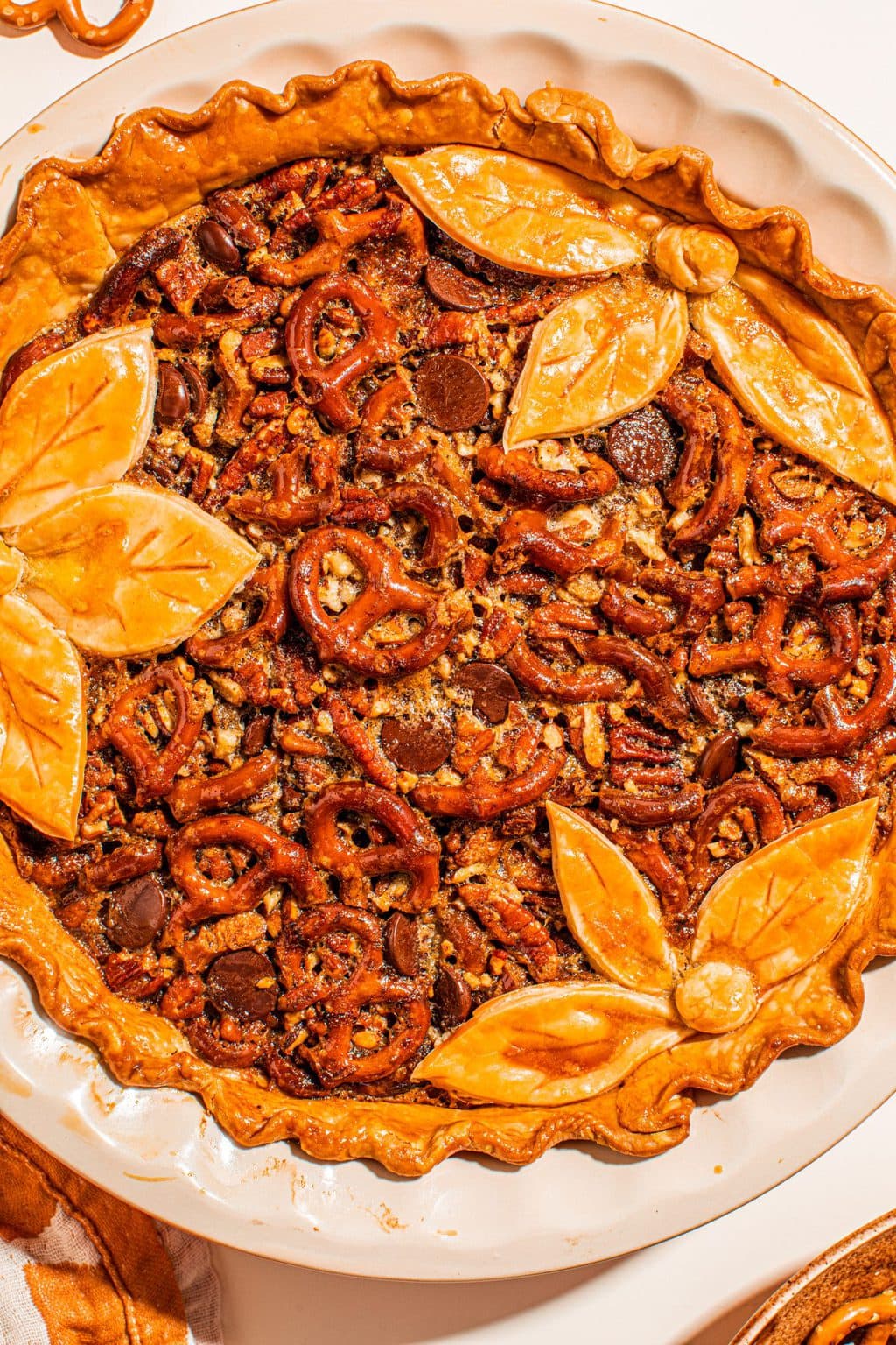 salted pretzel maple butter pecan pie with leaf decorations