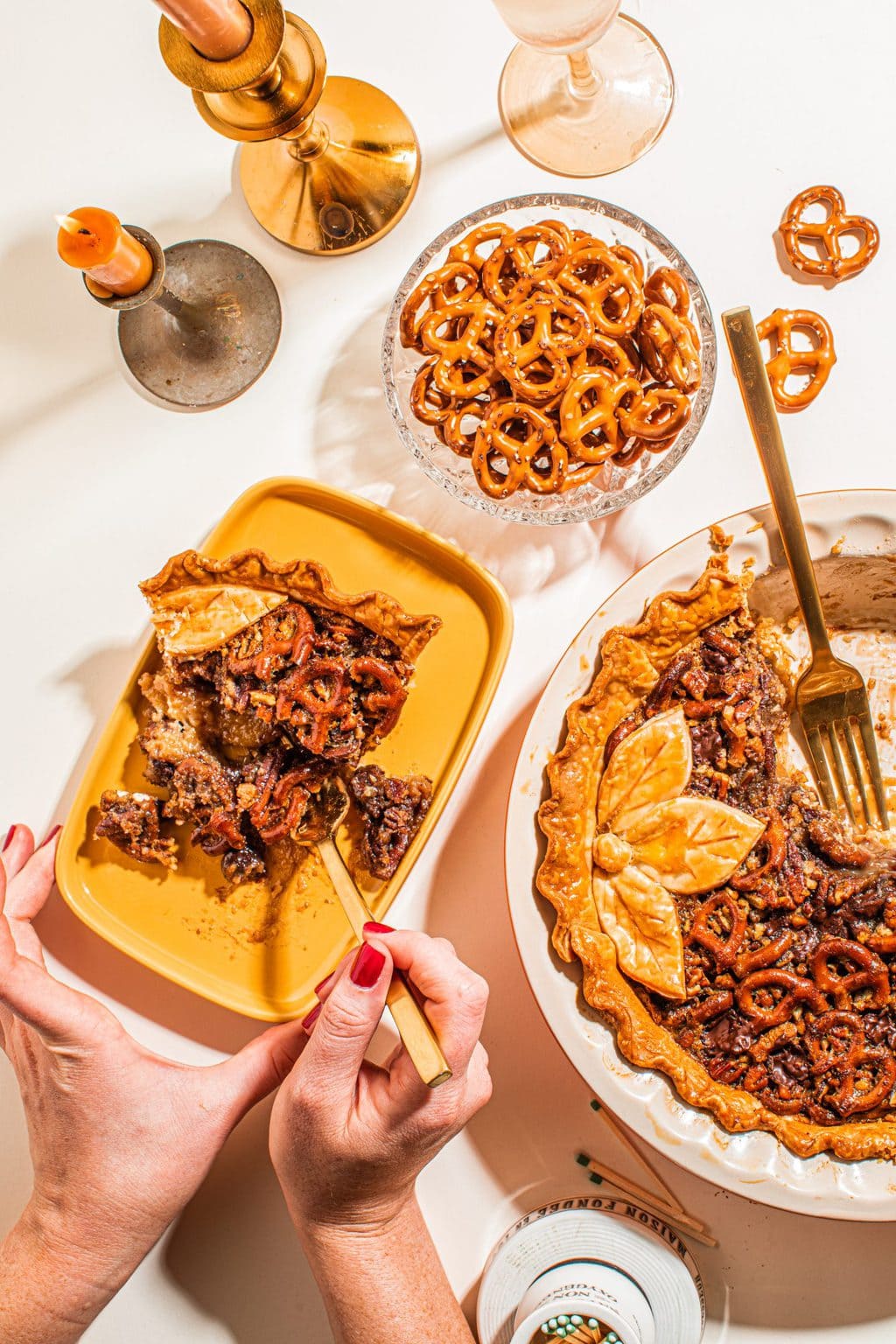 slice of pecan pie on yellow plate with whole pie on the side