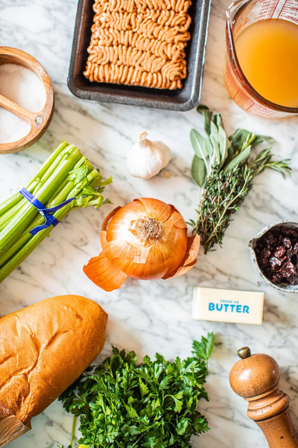 ground sausage, salt, celery, onion, herb bundle, cranberries, butter, pepper mill, parsley, bread