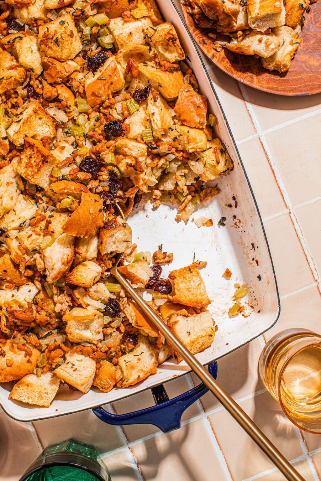 easy sausage stuffing in white baking dish with serving spoon