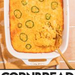 baked cornbread casserole in white casserole dish with serving spoon