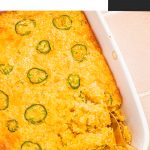 baked cornbread casserole in white casserole dish with serving spoon