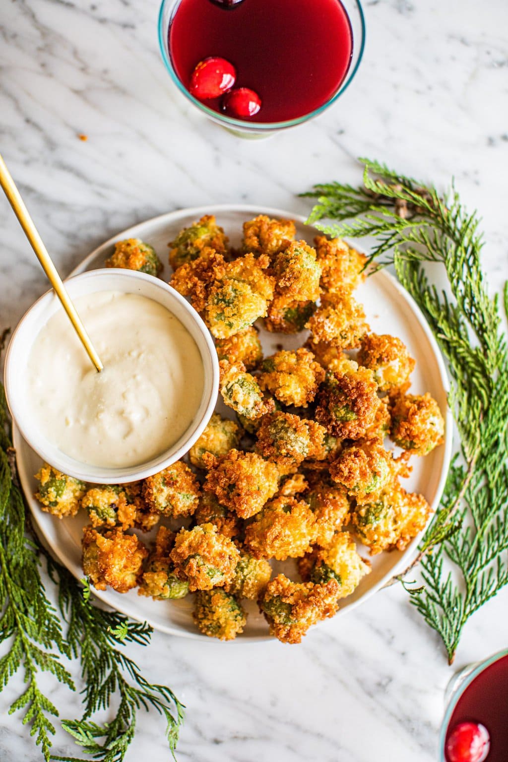 deep fried olives stuffed with blue cheese on white platter with aioli