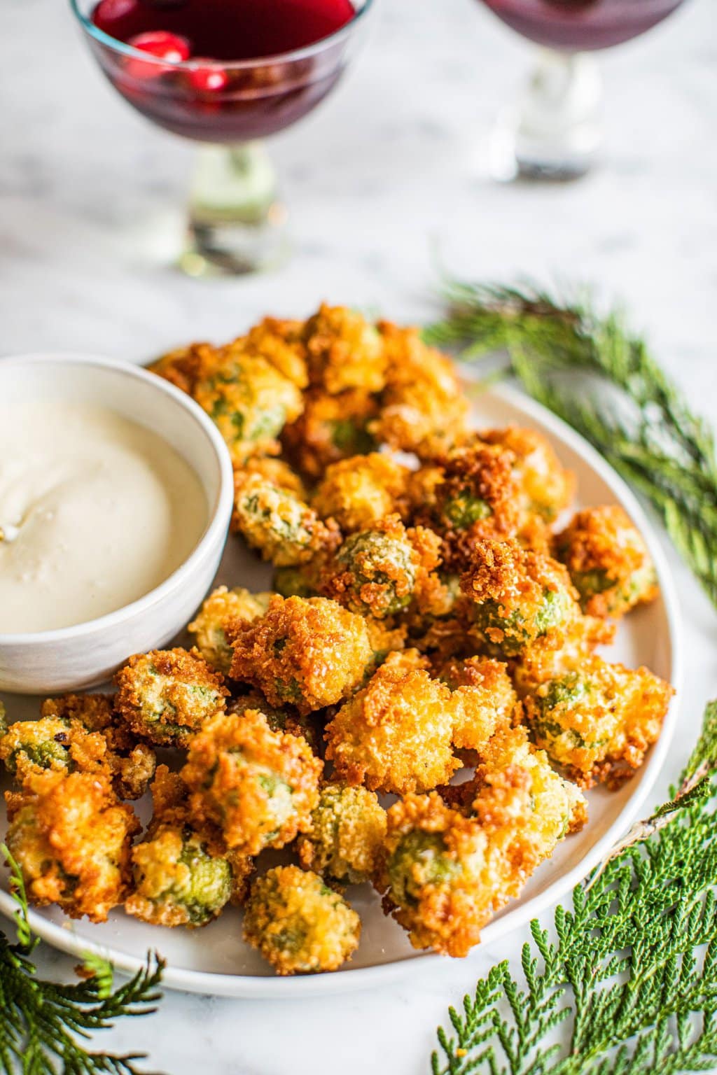 deep fried olives stuffed with blue cheese on white platter with aioli