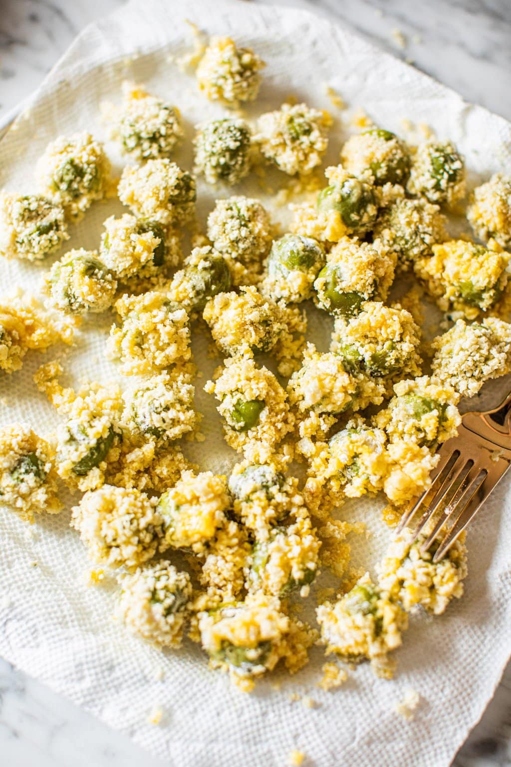 deep fried green olives on paper towels with fork