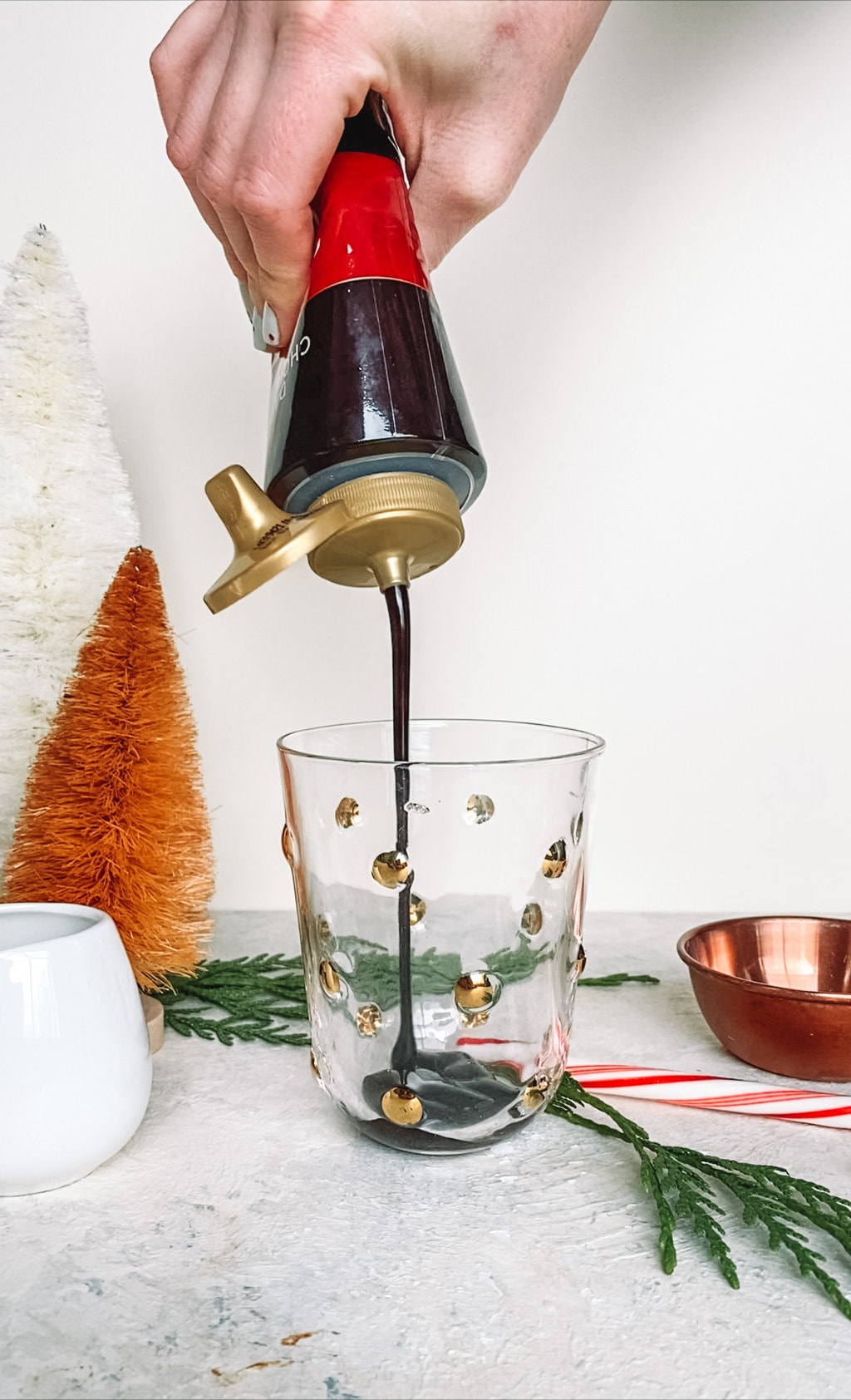 Chocolate sauce being poured into a glass. 