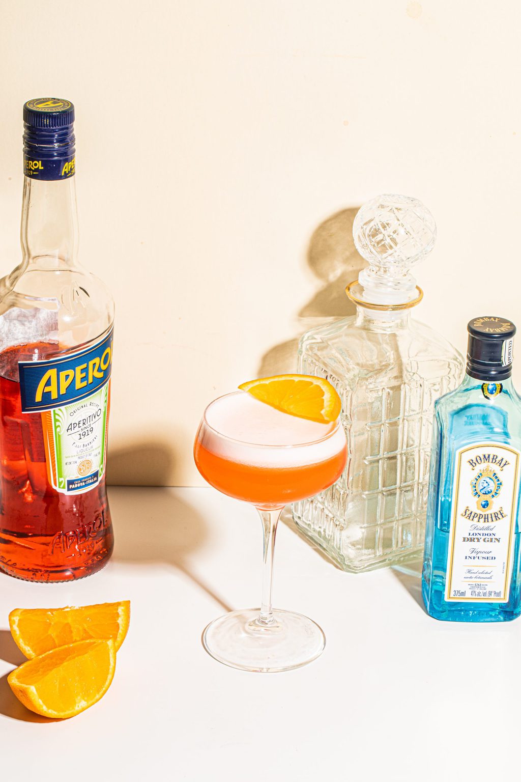 gin aperol cocktail in coupe glass garnished with orange