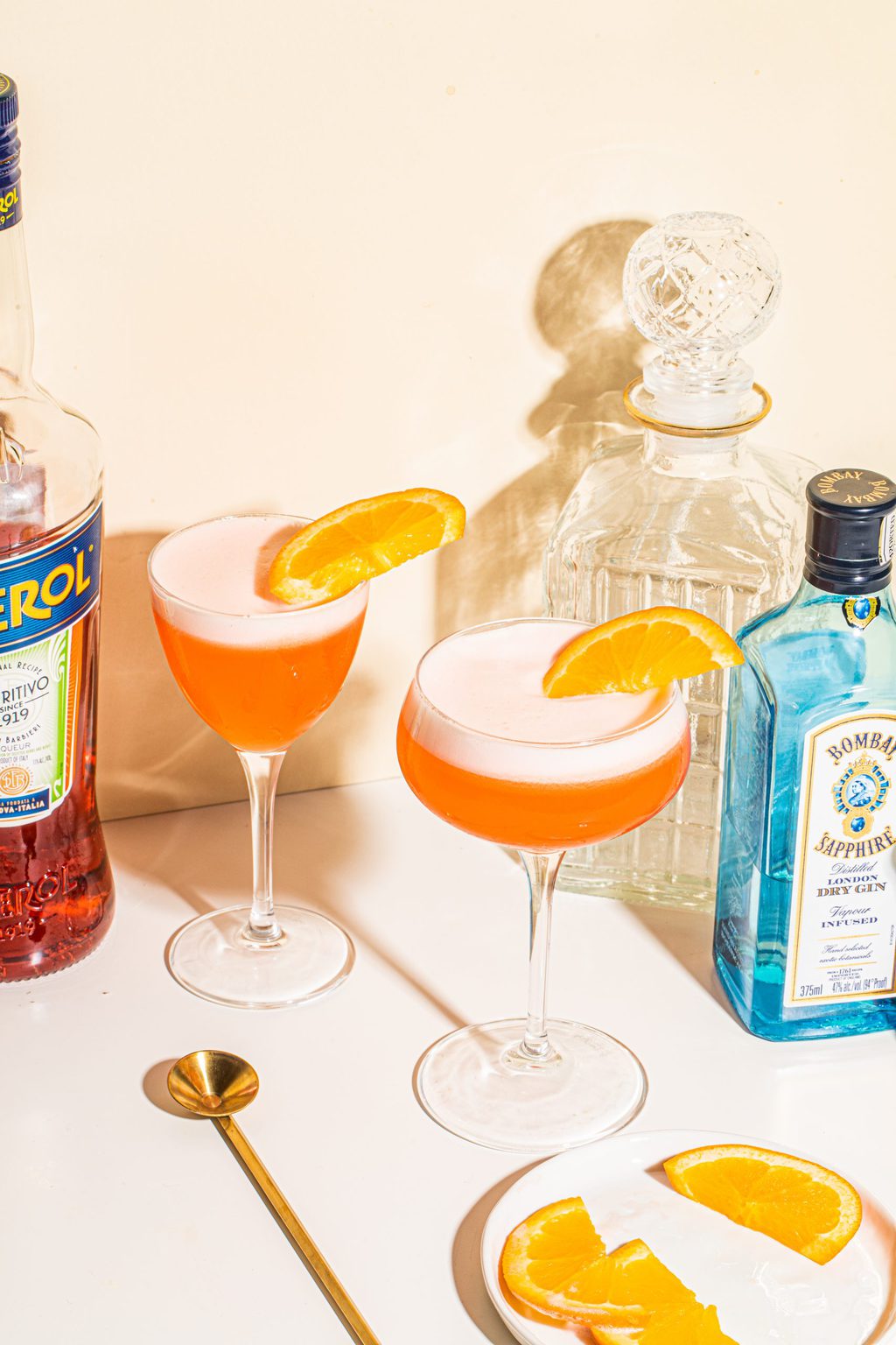 two glasses of aperol sour cocktail with orange slices