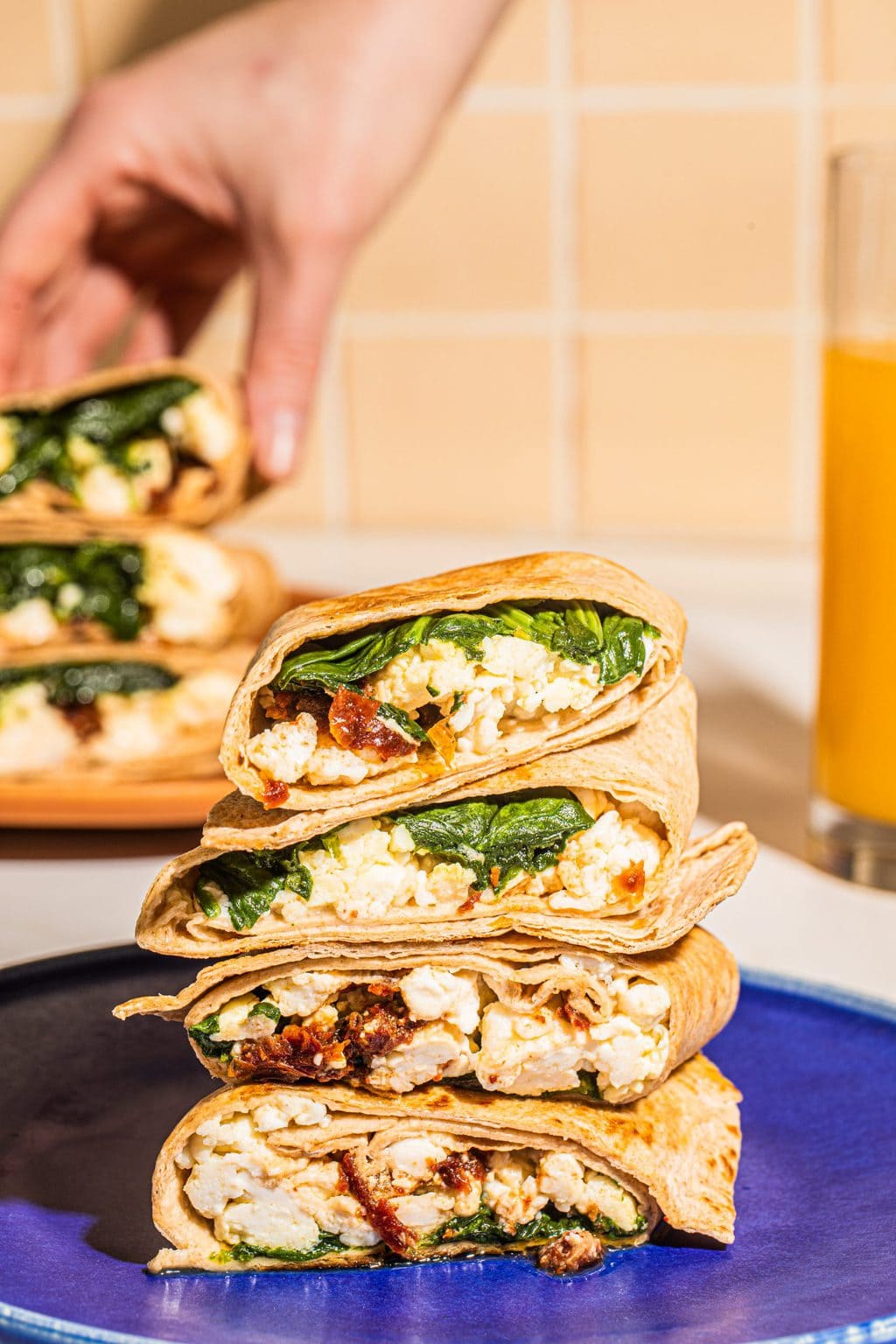 stack of spinach feta wrap halves on a blue plate