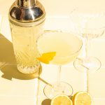 limoncello martini poured into coupe glass with cocktail shaker on side