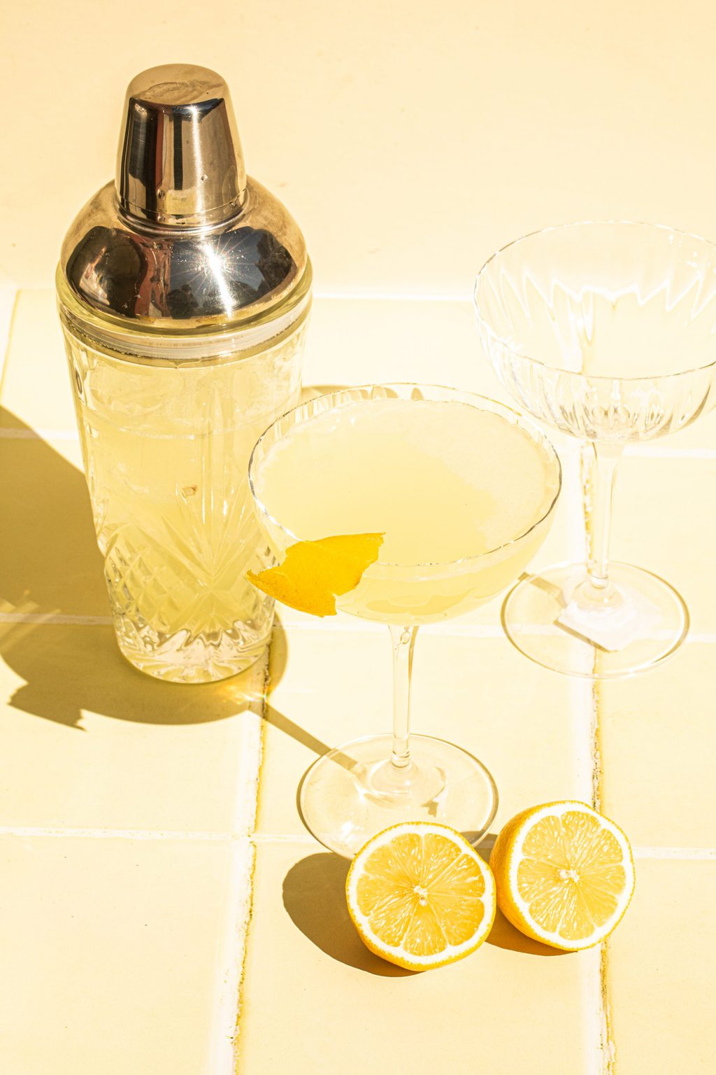 limoncello martini poured into coupe glass with cocktail shaker on side