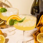 coupe glass filled with limoncello spritz and a bottle of prosecco