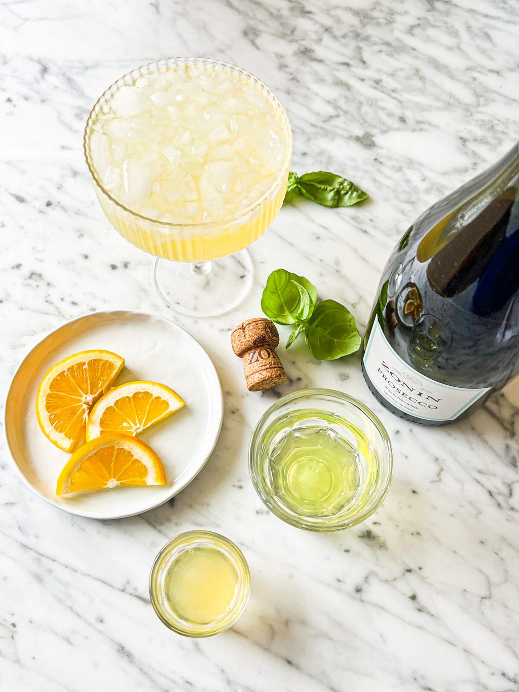 lemon slices, limoncello, lemon juice, prosecco and basil leaves