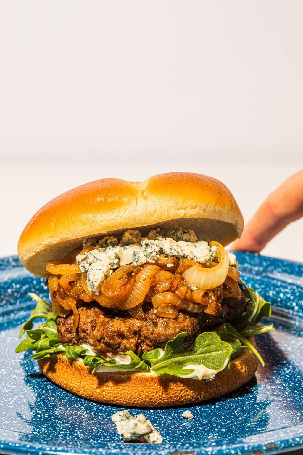 blue cheese burger with caramelized onions on blue plate