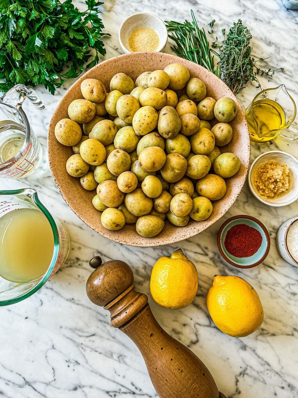 small gold potatoes, parsley, rosemary, thyme, white wine, chicken stock, lemons, garlic, spices