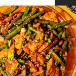 chinese chicken with string beans and garlic sauce on glass platter