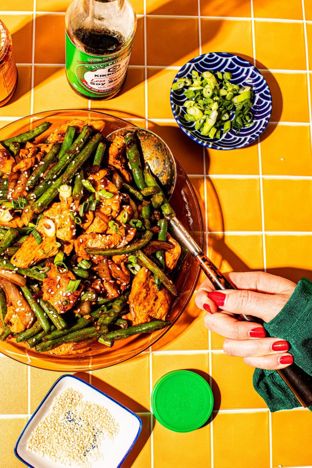 hand scooping chicken string bean stir fry with large spoon