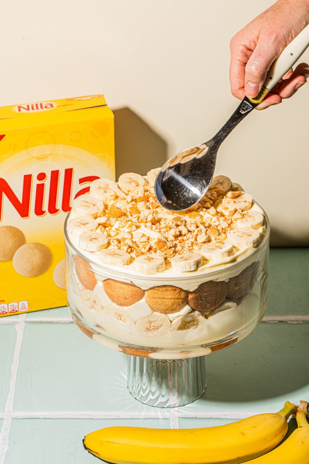 layered banana pudding recipe in trifle dish with Nilla wafer box