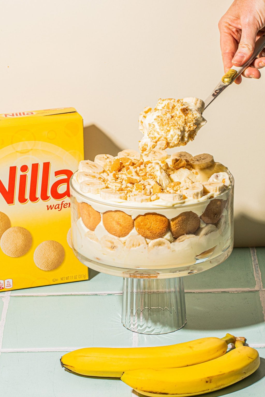 scooping a spoonful of banana pudding from trifle dish