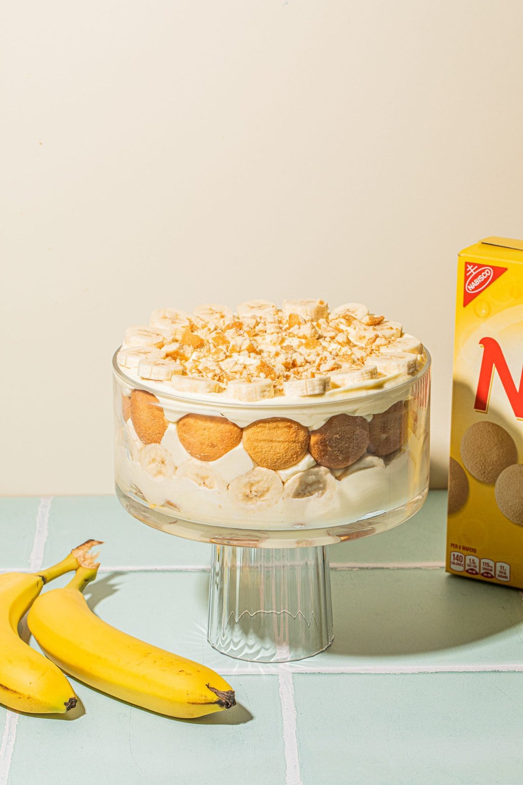 layered banana pudding recipe in trifle dish with Nilla wafer box