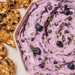 blueberry goat cheese dip in bowl with crisps on the side