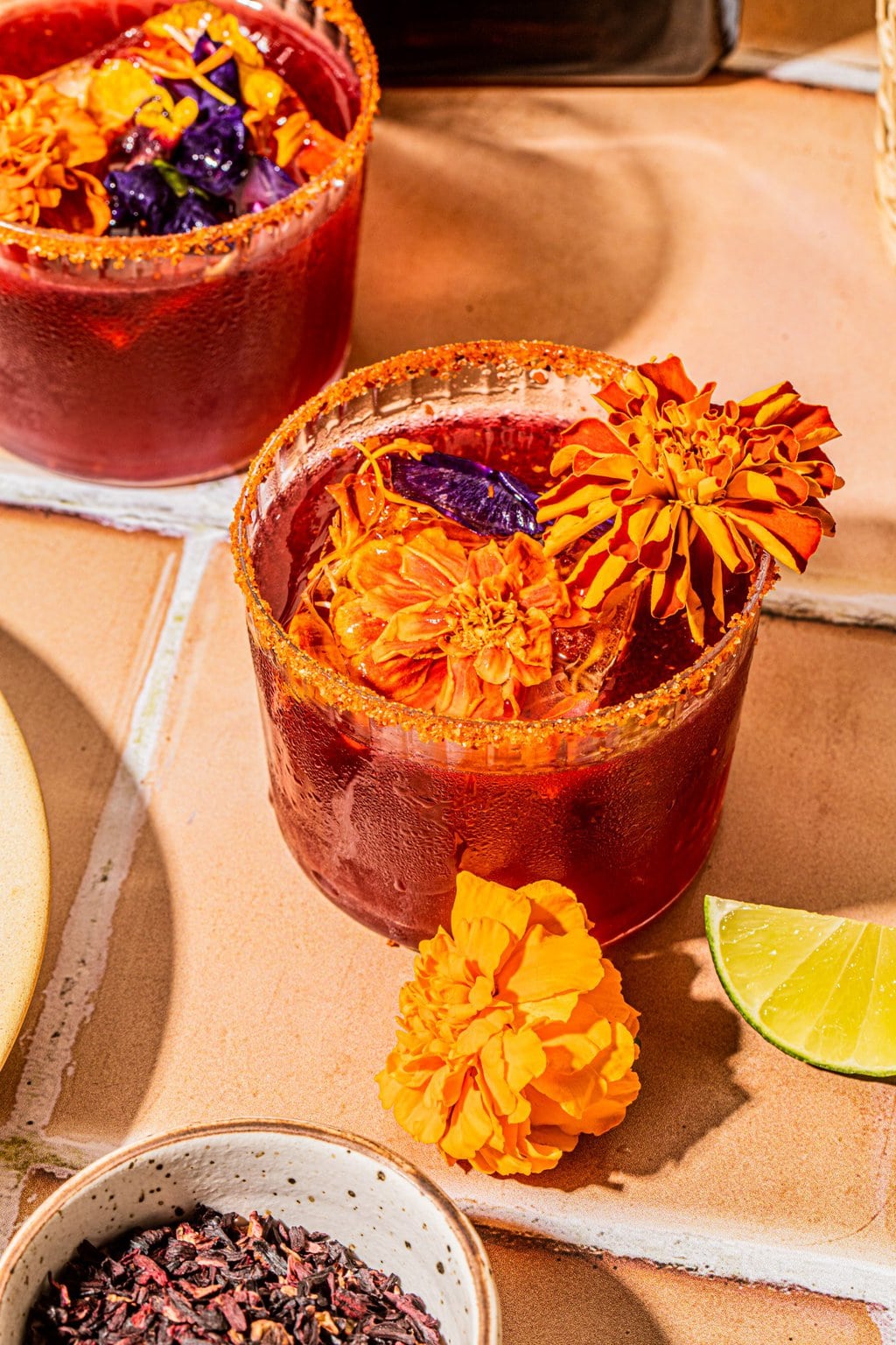 hibiscus margarita in glass with edible flower ice cube