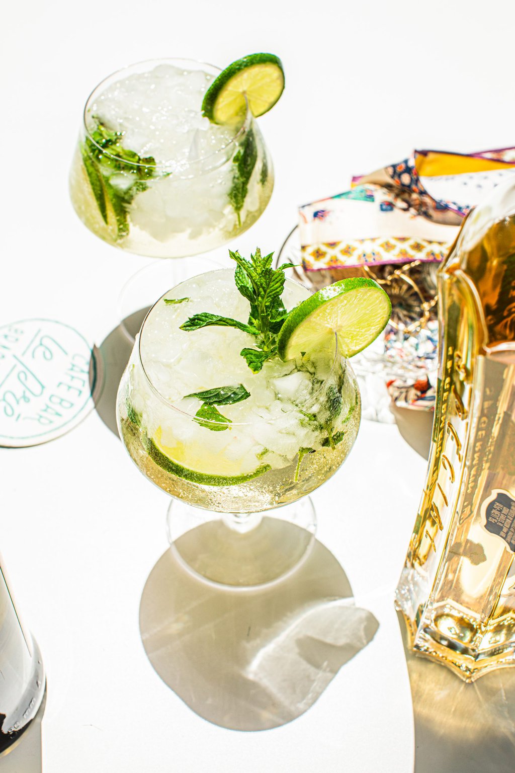 a wine glass filled with a hugo spritz and garnished with a mint leave and a lime wheel 