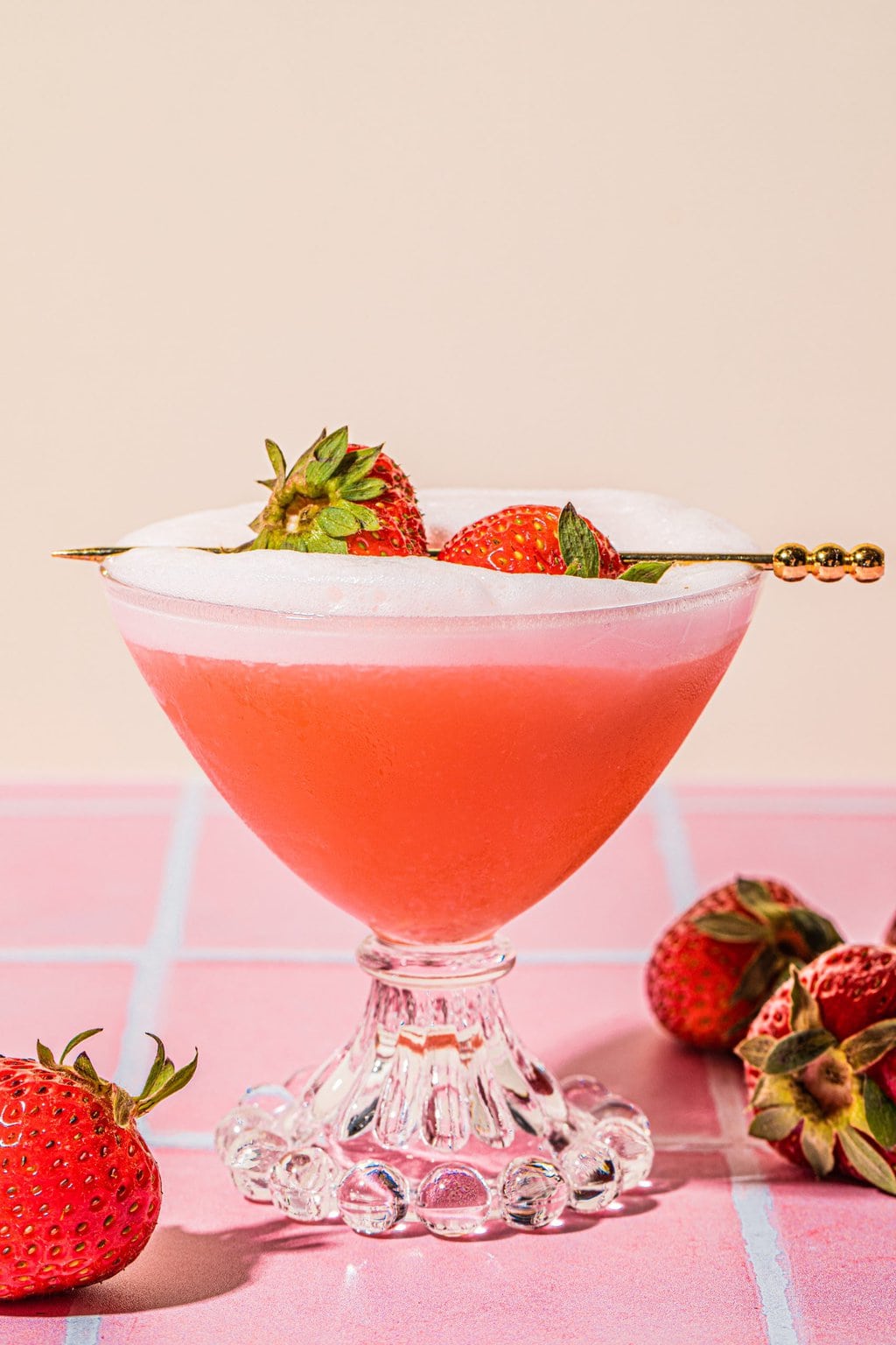 strawberry tequila sour in glass garnished with fresh strawberries