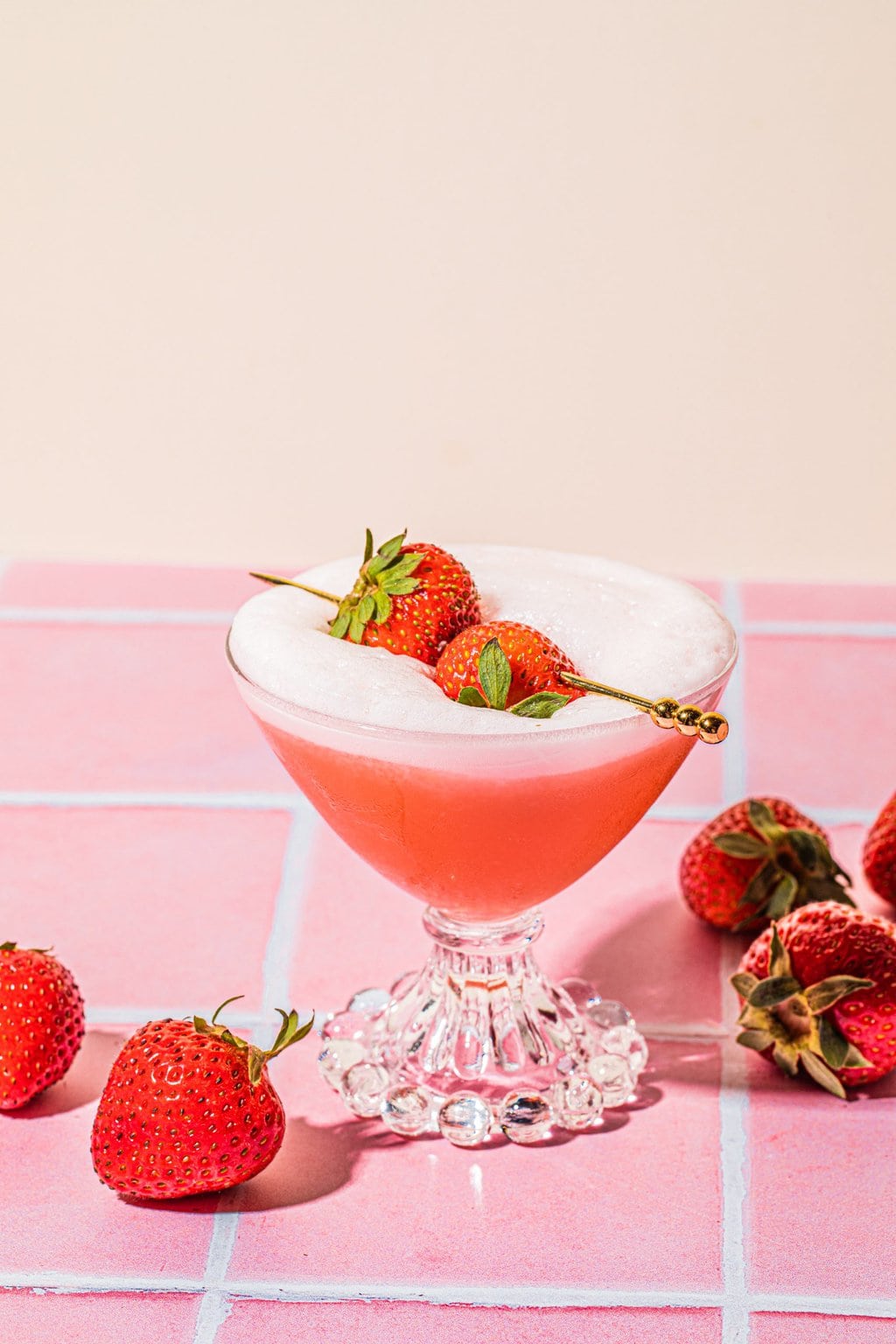 strawberry tequila sour in glass garnished with fresh strawberries