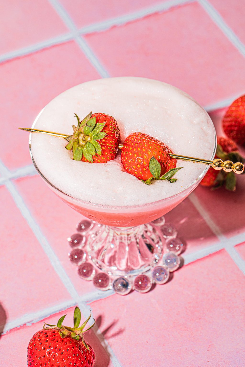 strawberry tequila sour in glass garnished with fresh strawberries