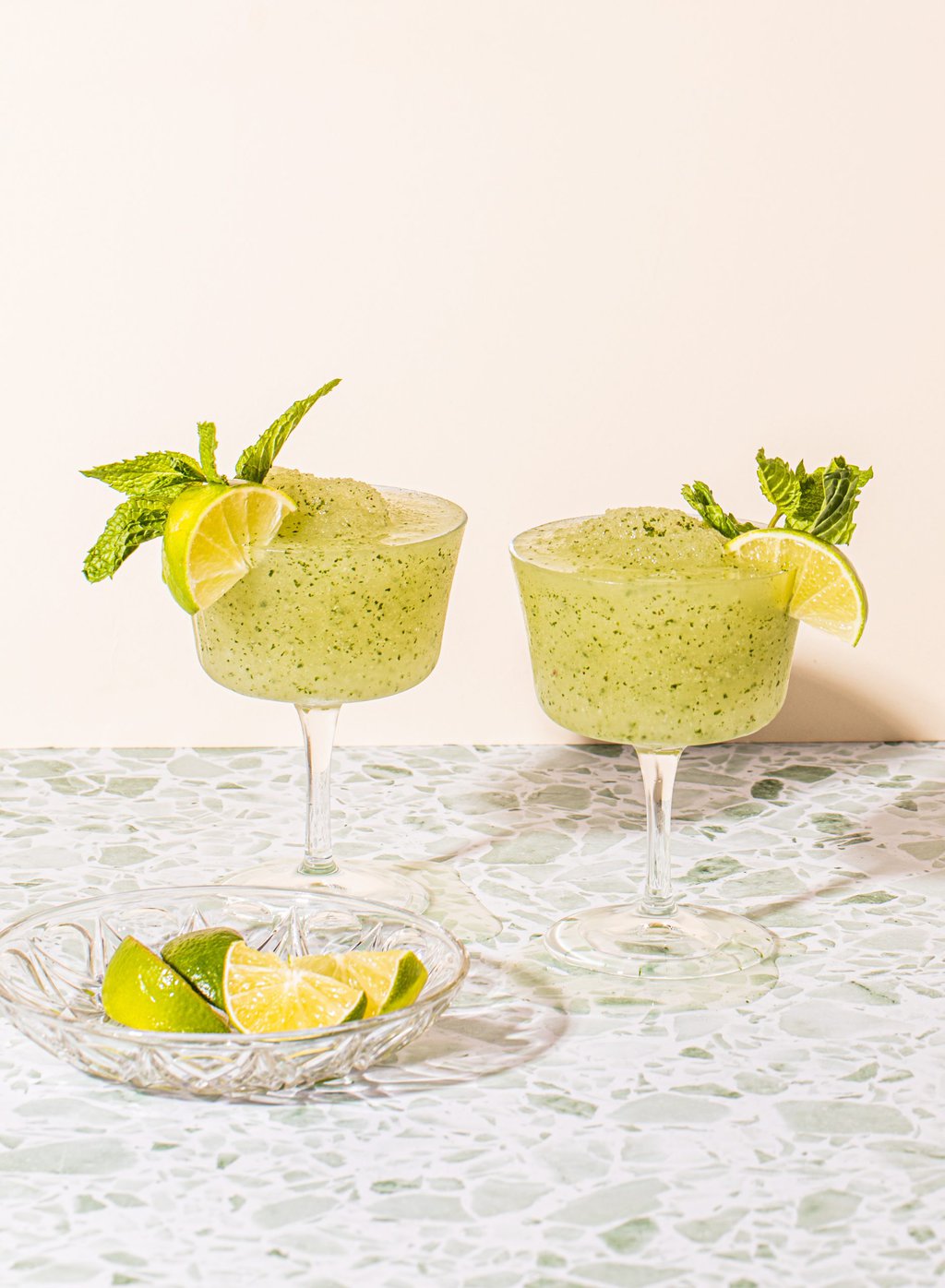 two frozen mojitos in stem wine glasses