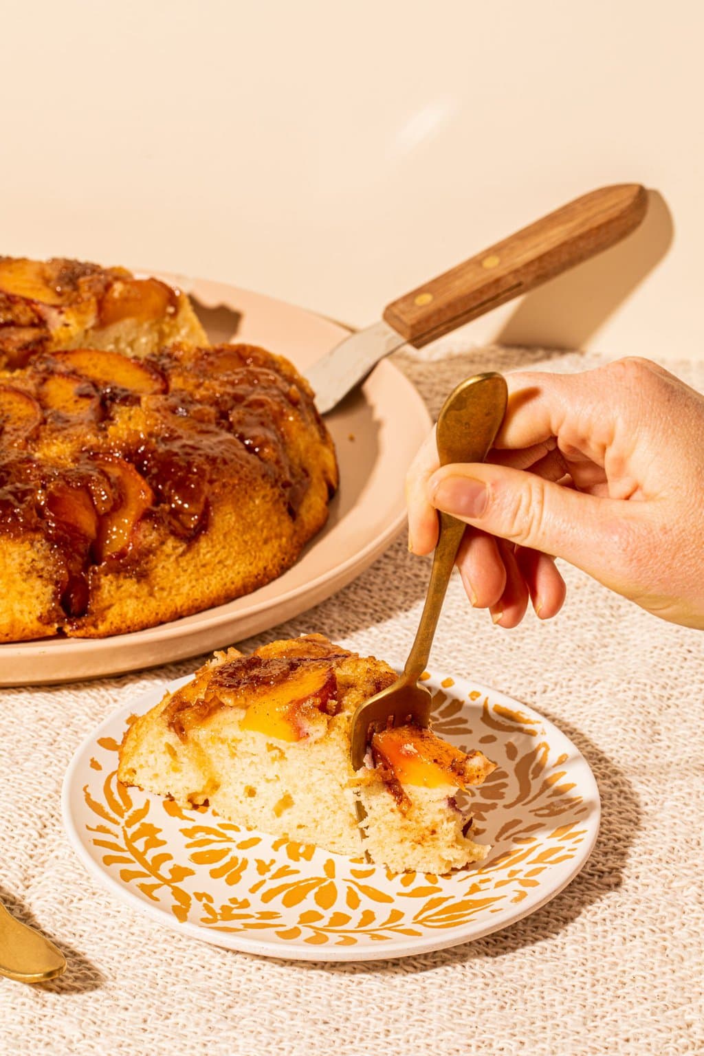 fork digging into slice of peach cake on plate