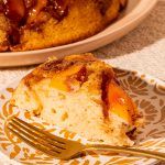 slice of peach cake on plate with fork
