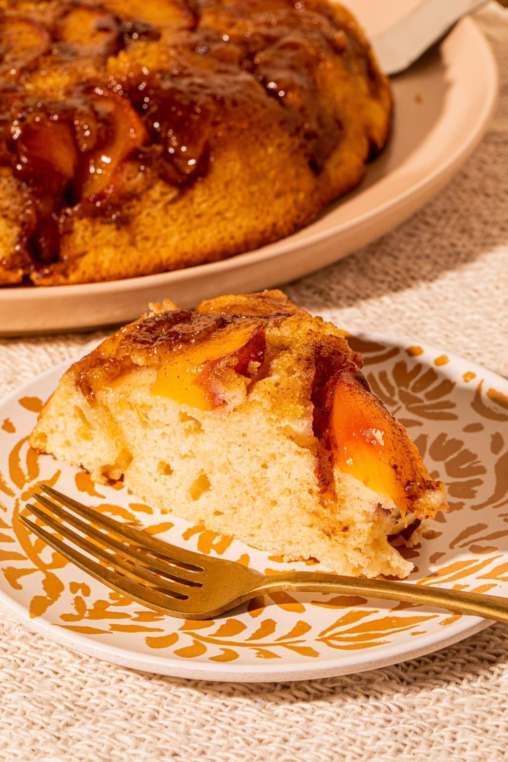 slice of peach cake on plate with fork