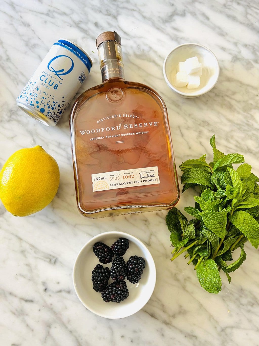 Club soda, woodford reserve whiskey, sugar cubes, lemon, blackberries, mint leaves 