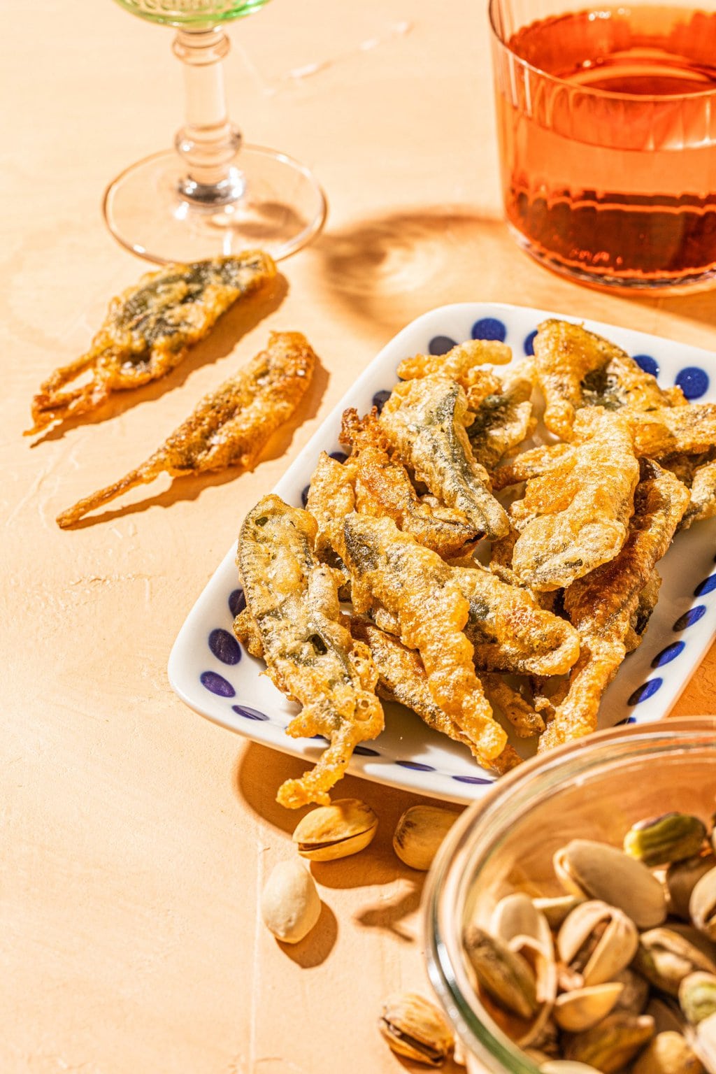 fried sage pieces on a white dish with blue polka dots 