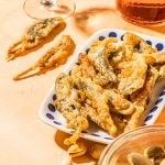 fried sage pieces on a white dish with blue polka dots