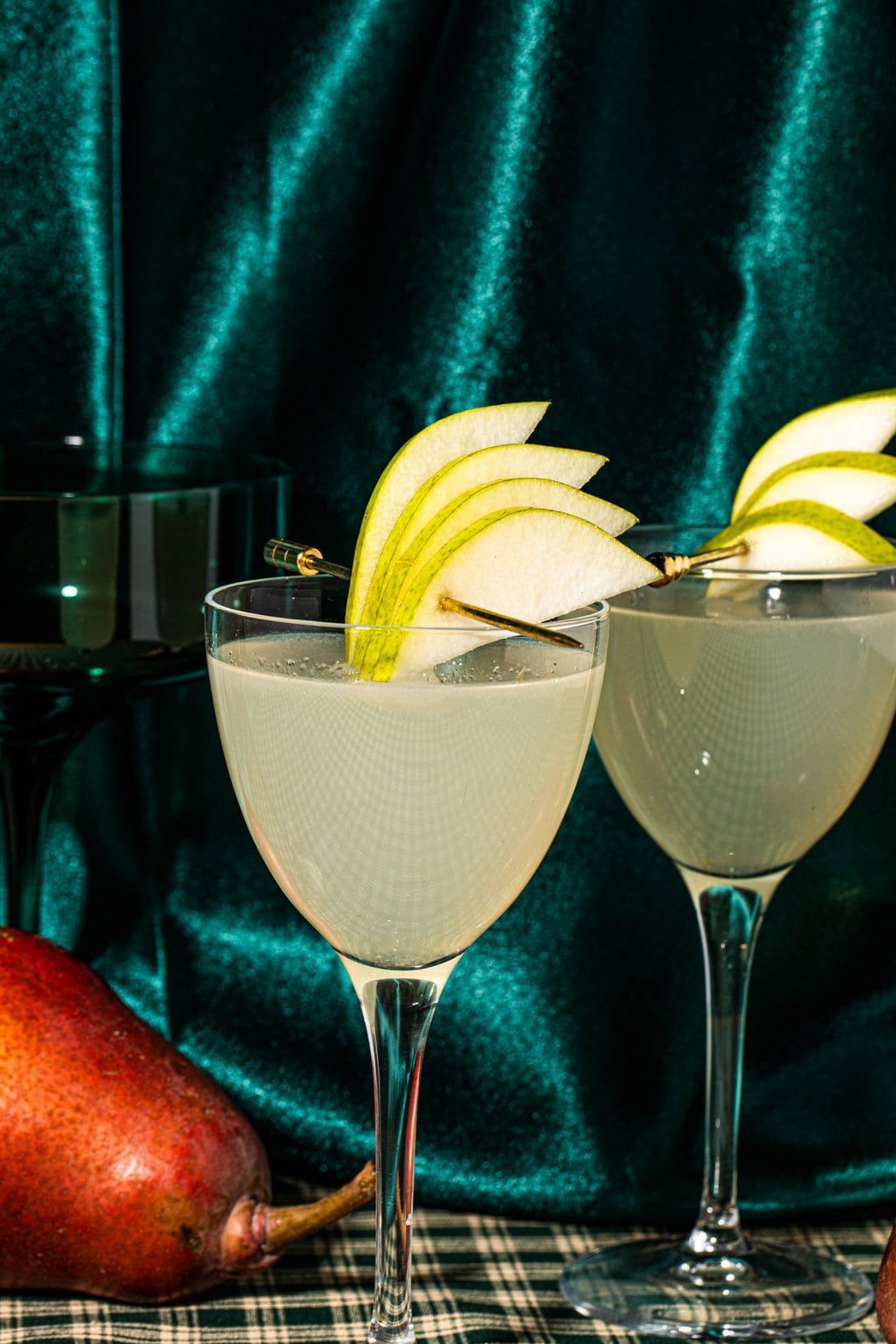 two pear martinis in glass garnished with fresh pear