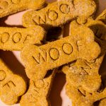 pile of peanut butter pumpkin dog treats on an orange surface