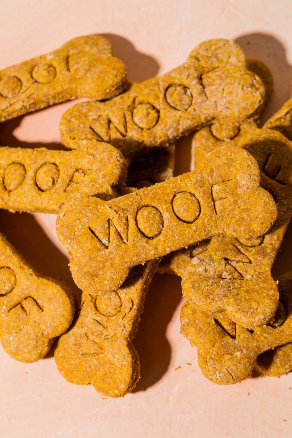 pile of peanut butter pumpkin dog treats on an orange surface