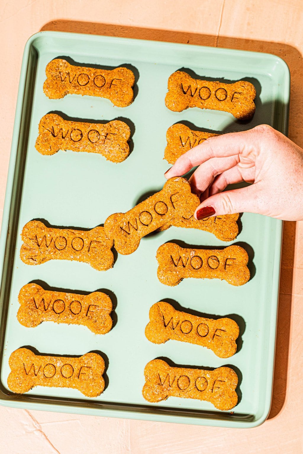 Green baking sheet with dog bone shaped biscuits 