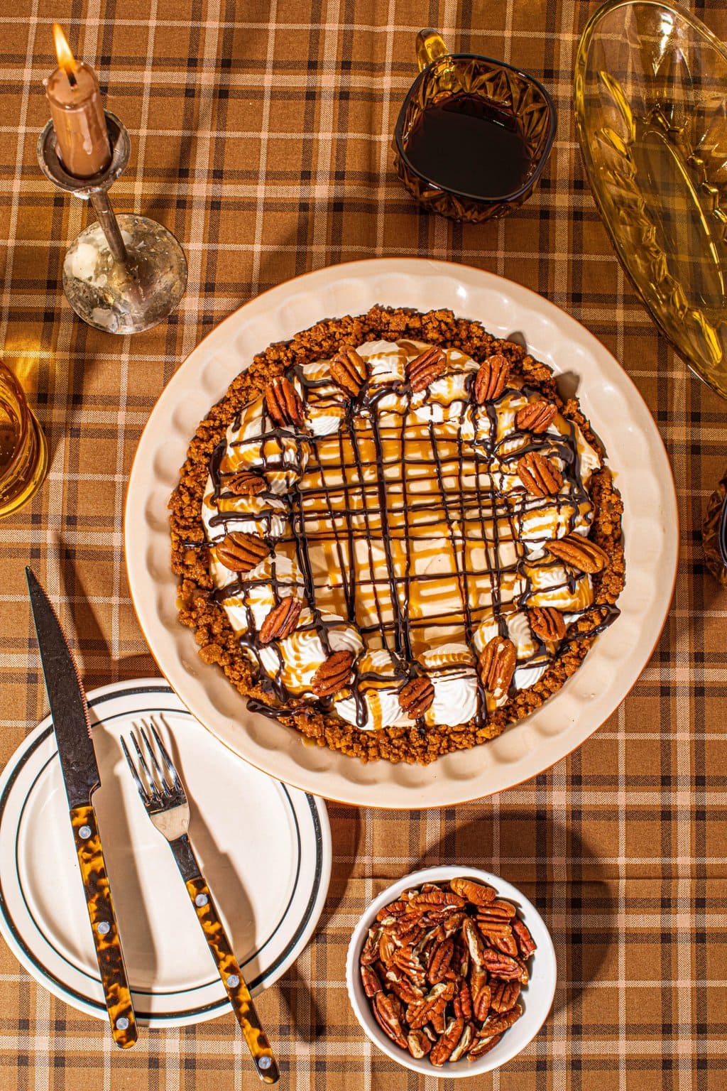 turtle pie in pie dish drizzled with caramel, chocolate and pecans