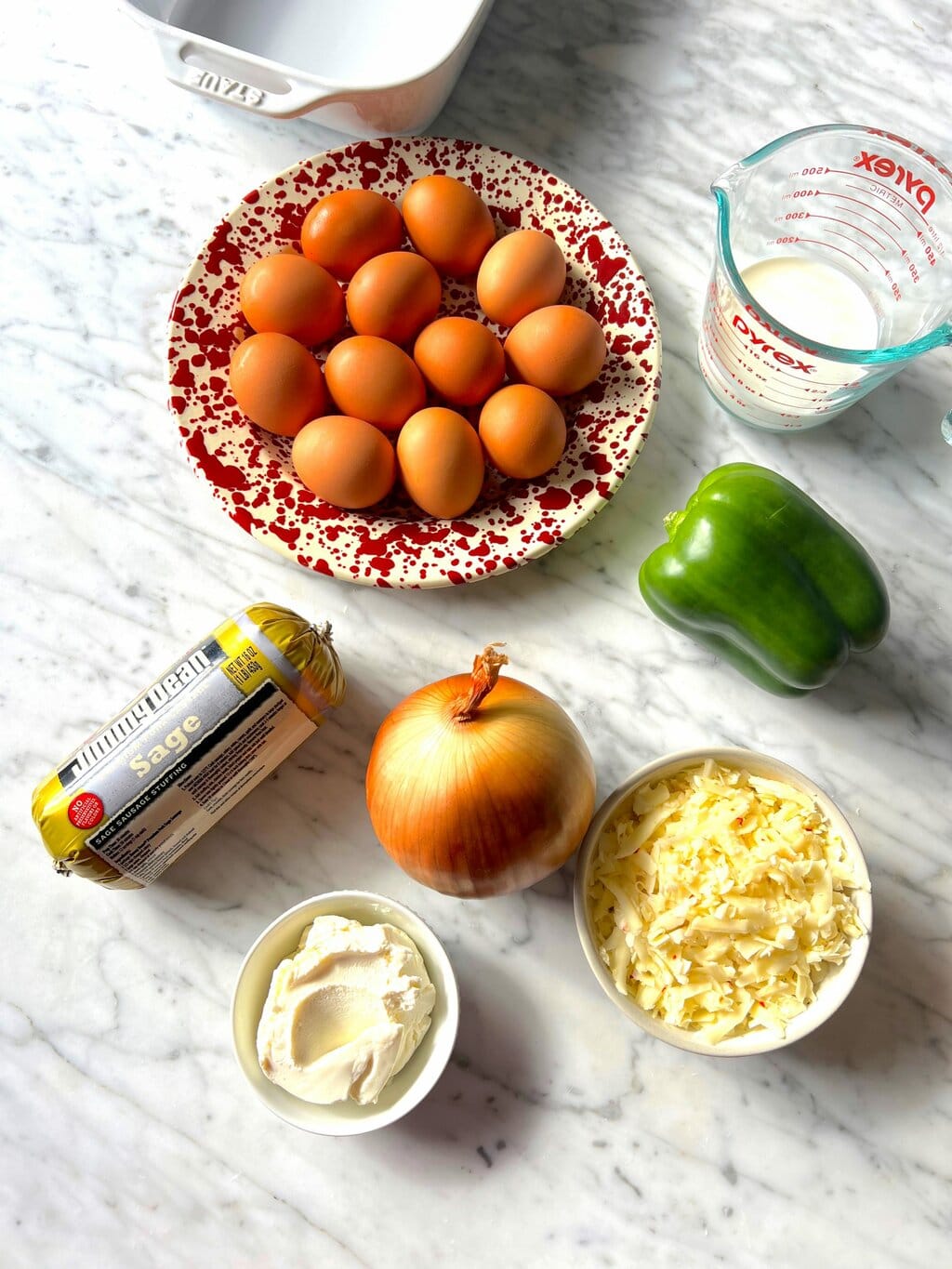 white baking dish, eggs, half and half, breakfast sausage, green pepper, onion, ricotta, shredded cheese