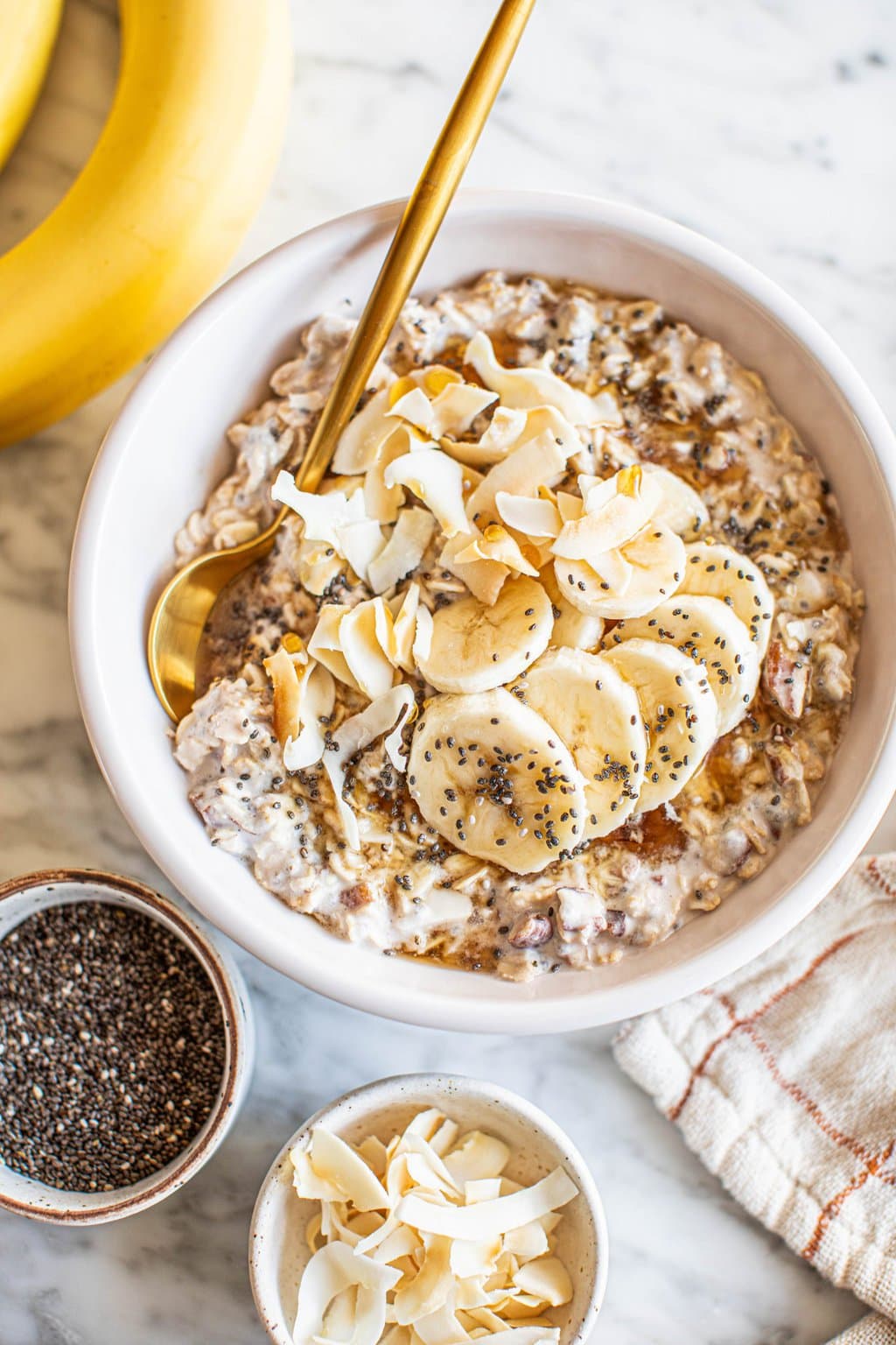 overnight oats with coconut milk in white bowl topped with banana slices