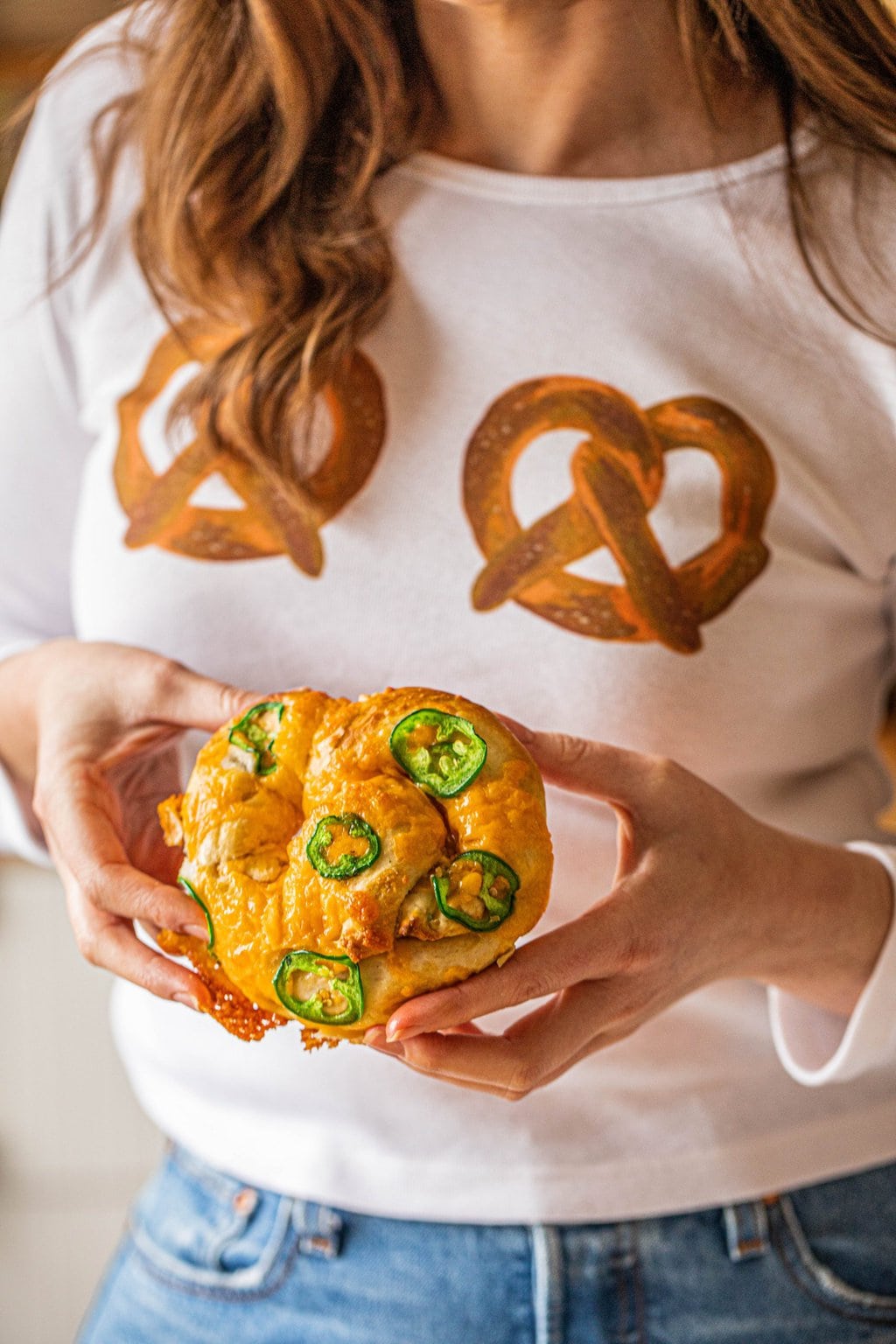 woman holding jalapeno cheddar pretzel in two hands