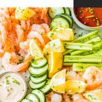 shrimp cocktail platter with celery, cucumbers, lemon wedges, cajun aioli and cocktail sauce