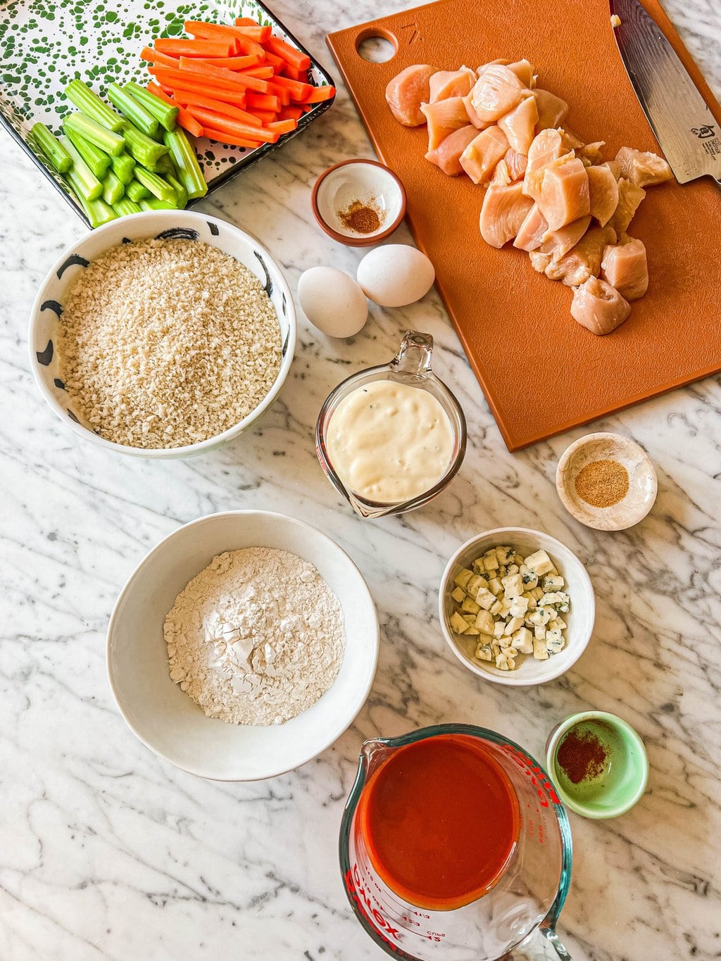 celery, carrots, cubed chicken breasts, breadcrumbs, eggs, flour, blue cheese, buffalo wing sauce, paprika