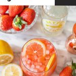 a strawberry drink in a cocktail glass with lemon slices