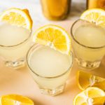 lemon drop shot with lemon wedges on cutting board